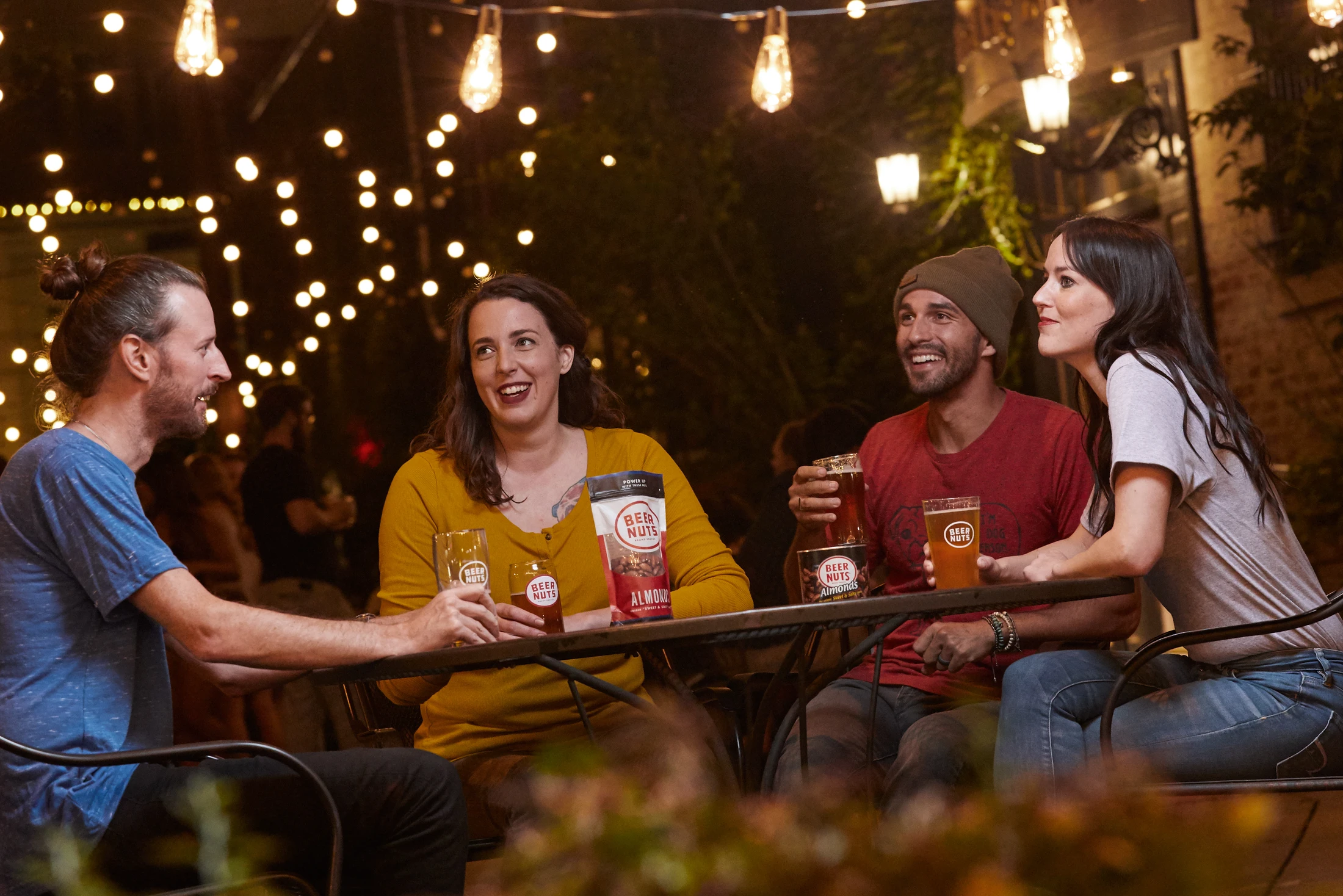 A group of people sitting around a table drinking beer.