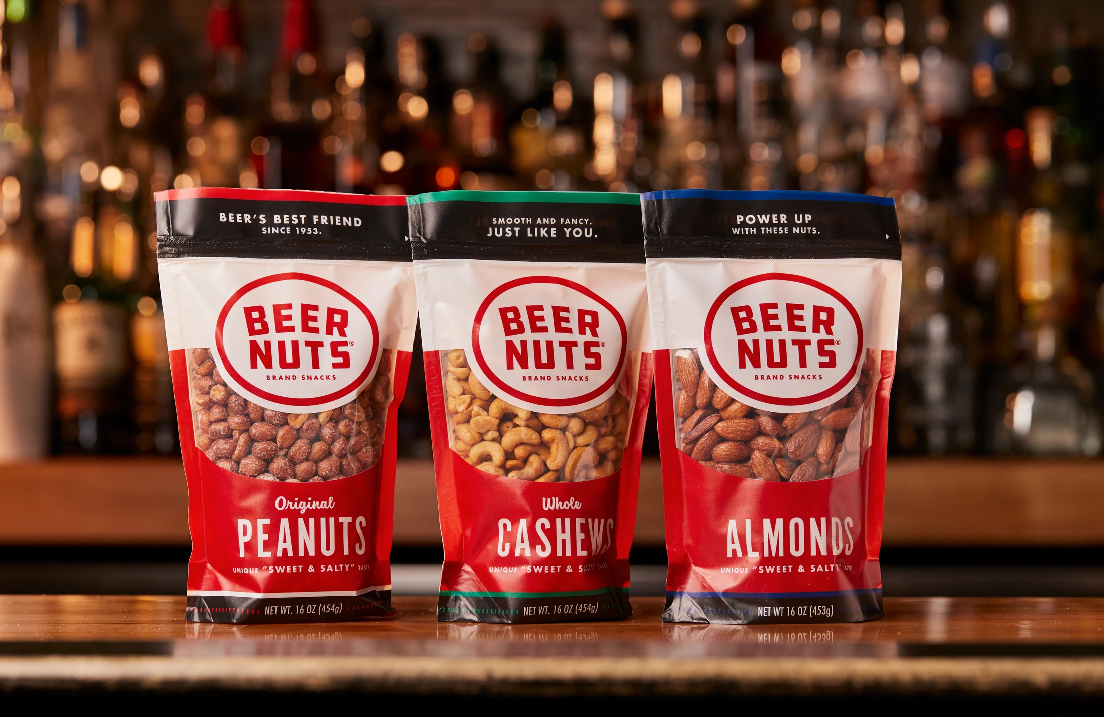 Three bags of Beer Nuts sitting on a bar.