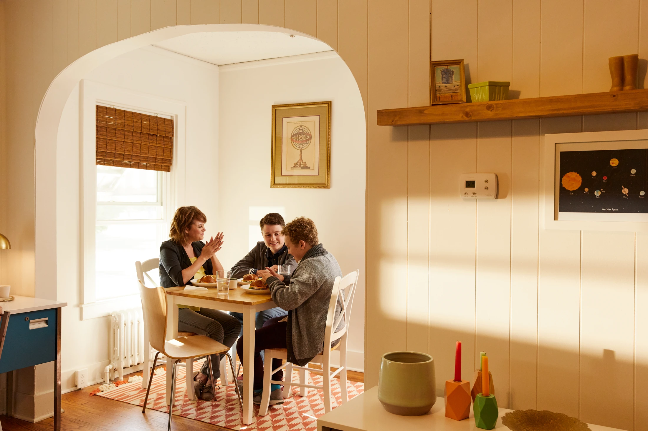 A group of people sitting at a table in a kitchen.