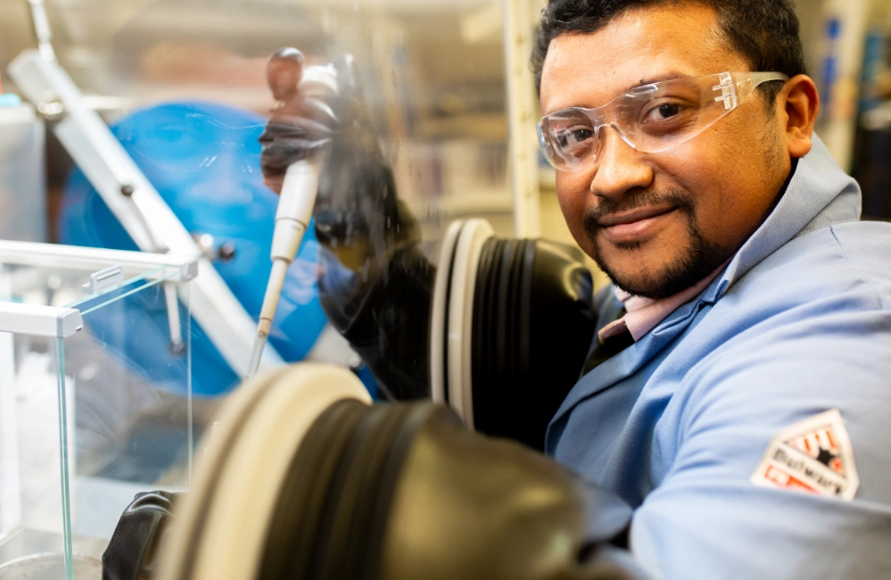 An man using a scientific device while smiling at the camera.