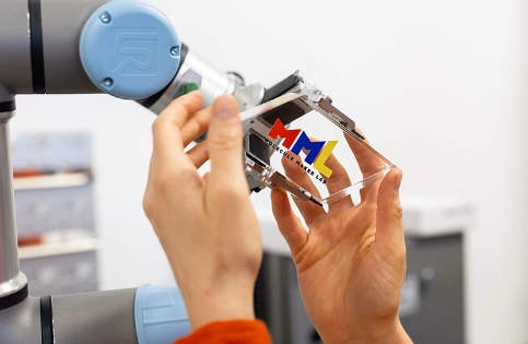 A pair of hands placing a parallogram shaped MML branded shape into a clamp.