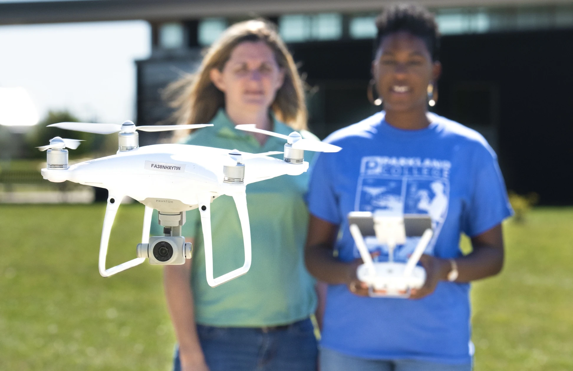 A photo of two people holding a drone.
