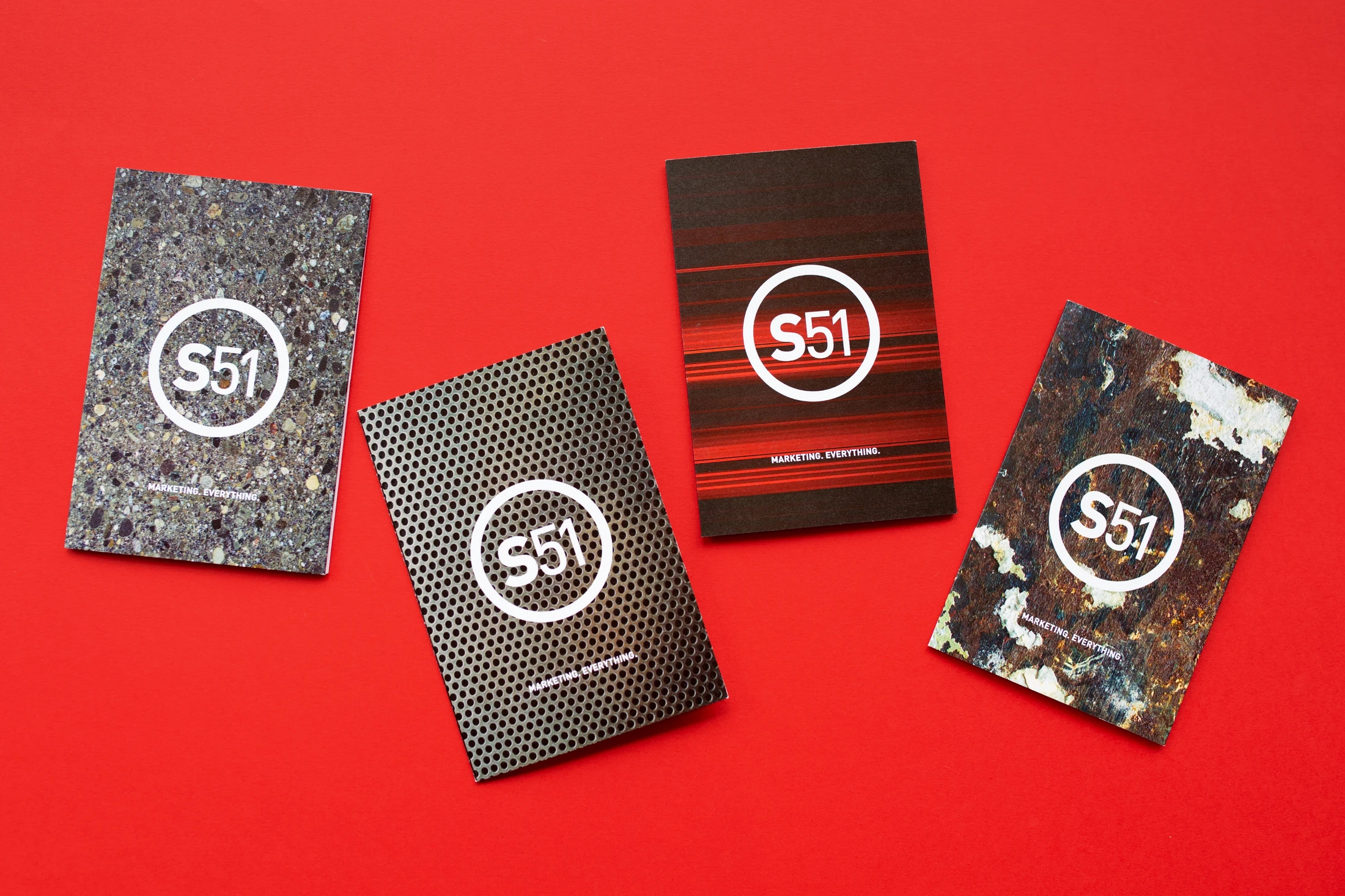 Four business cards on a red surface.