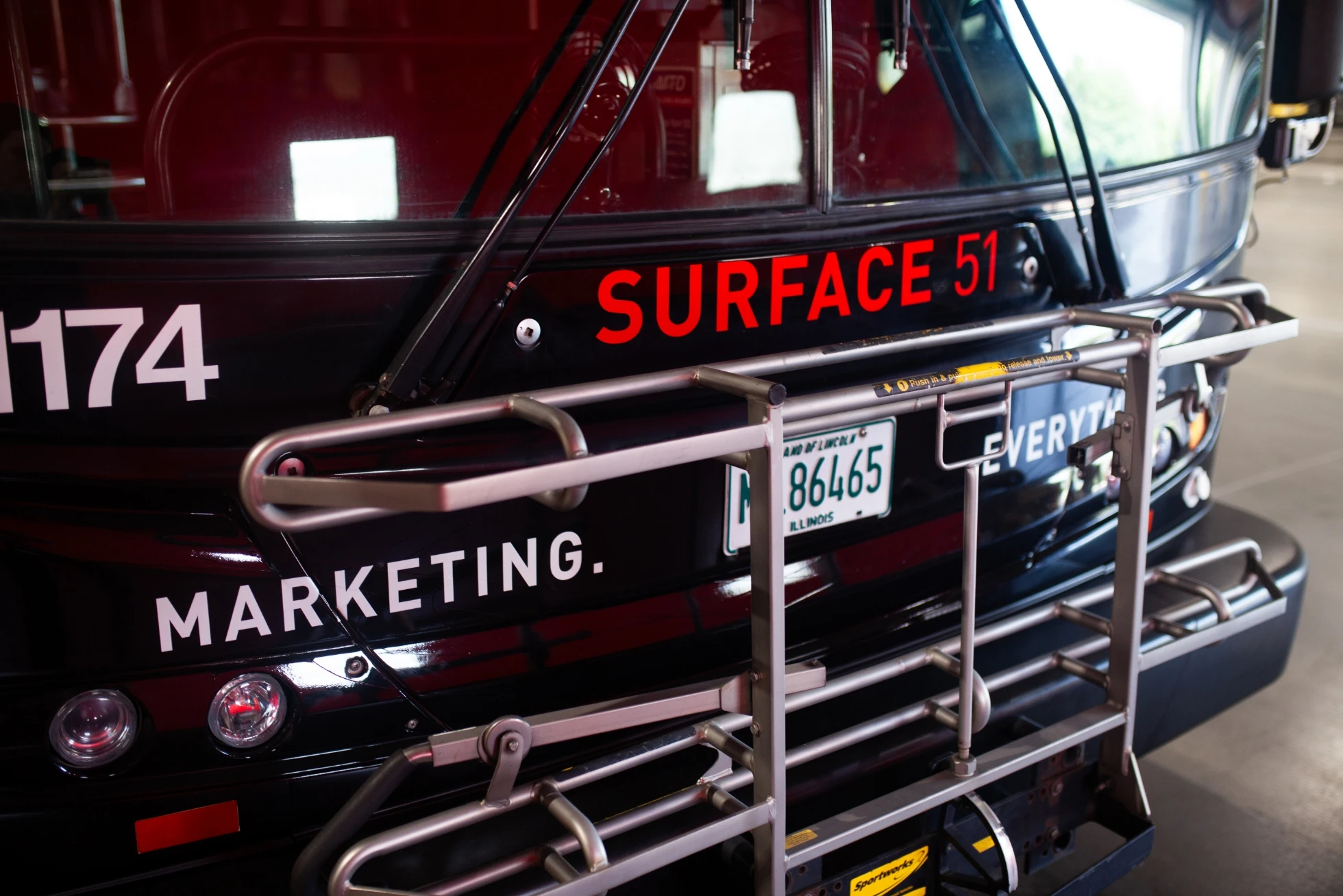 The back of a bus with a marketing sign on it.