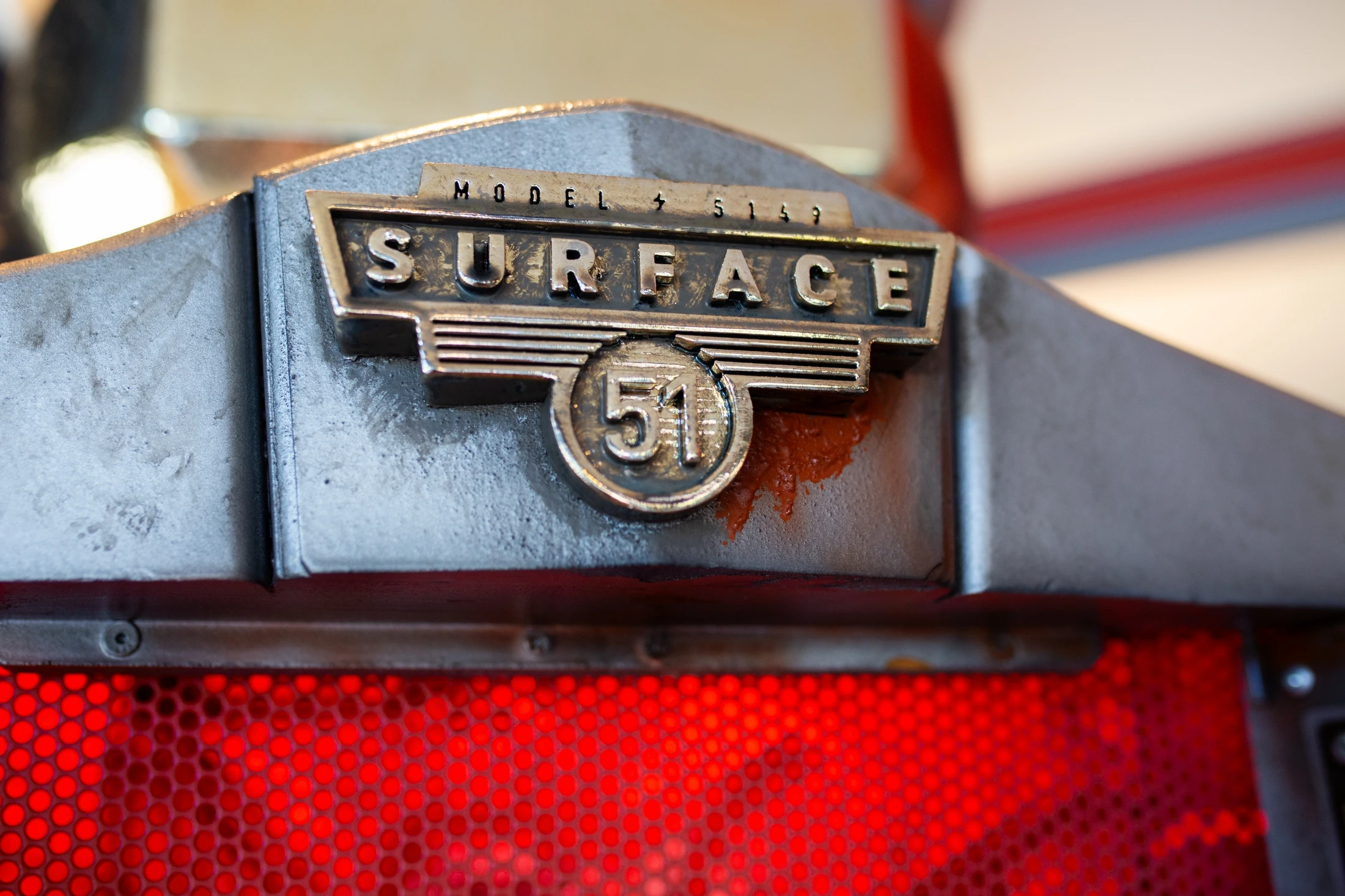 A close up of a badge with the word surface on it.
