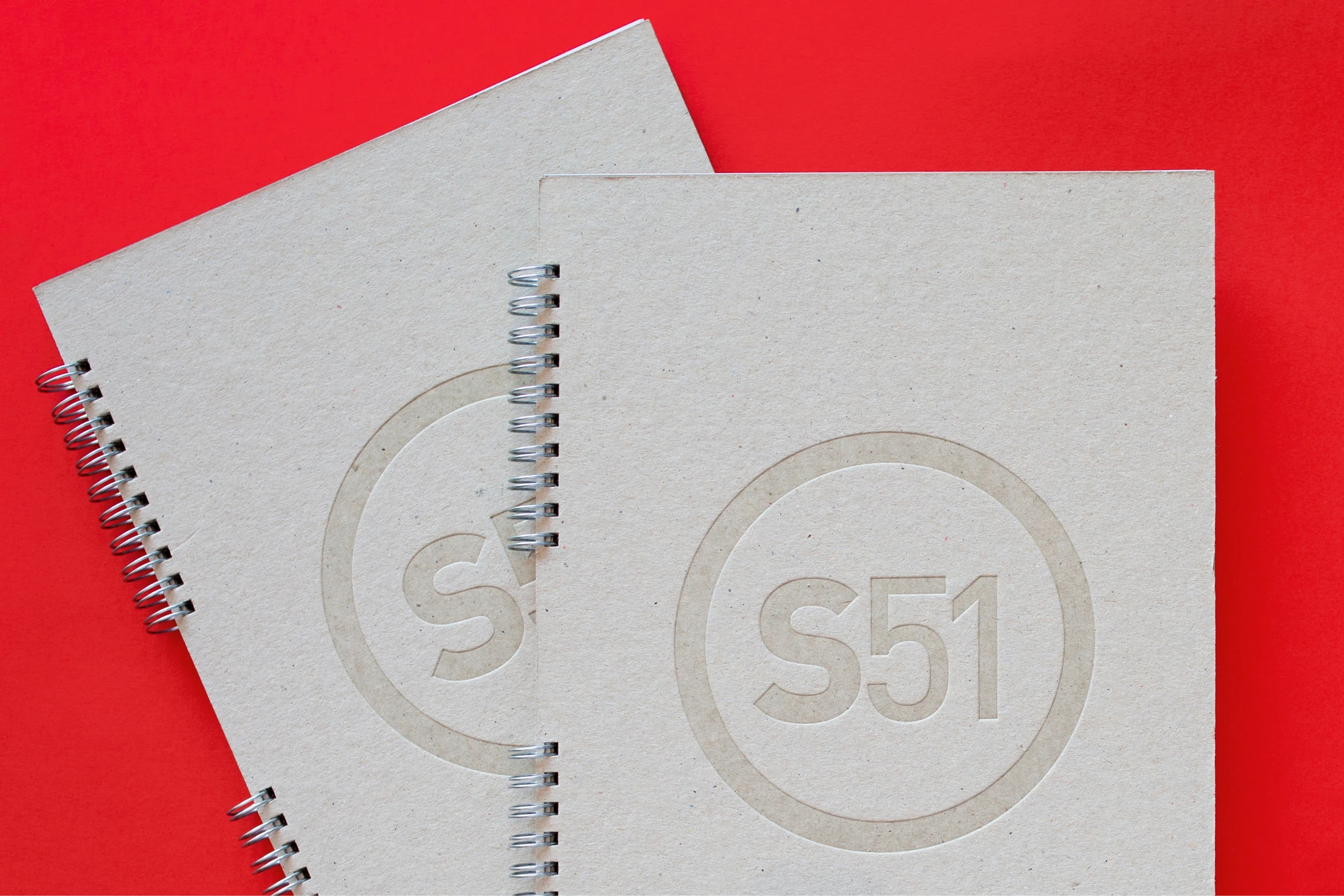 Two notebooks and a stamp on a red background.