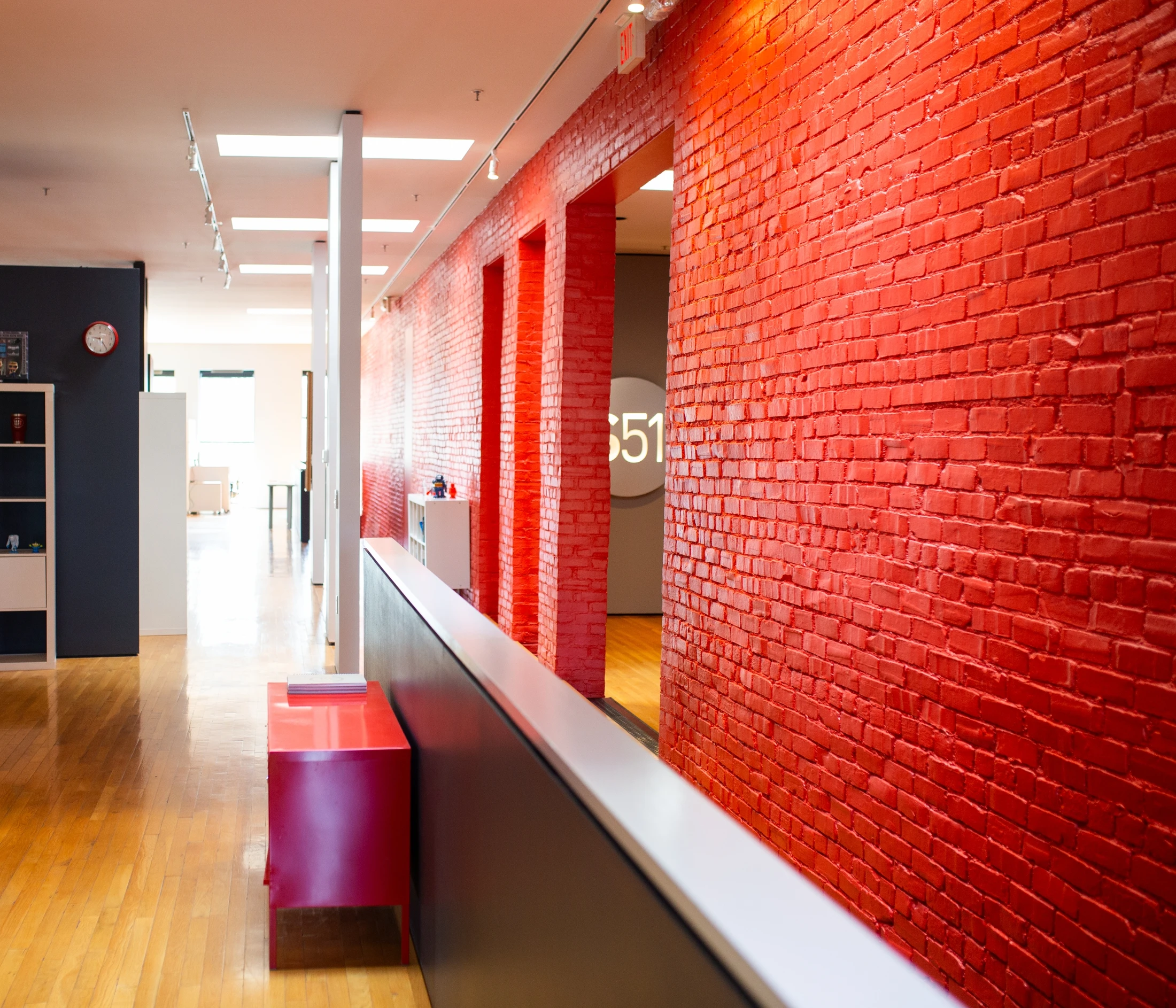 An office with red brick walls and a bench.
