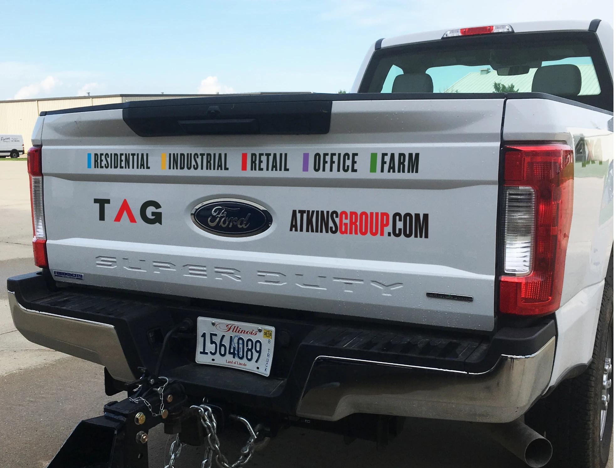 The back of a white truck with a tag on it.