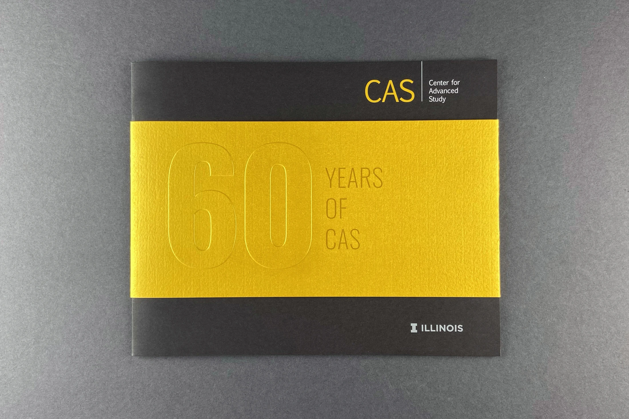 A yellow and black booklet with the words caas 60 years of caas.