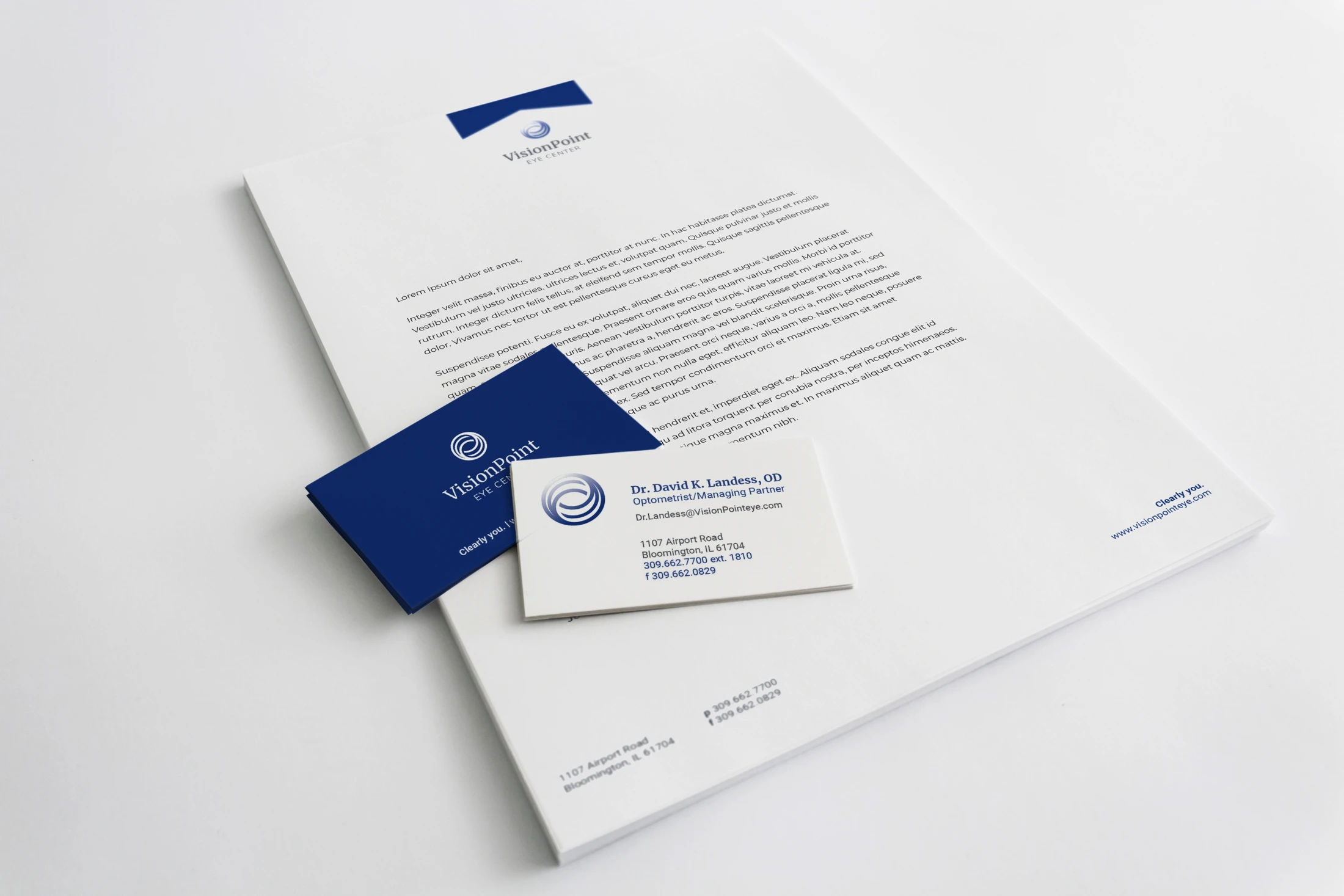 A business card and letterhead on a white surface.